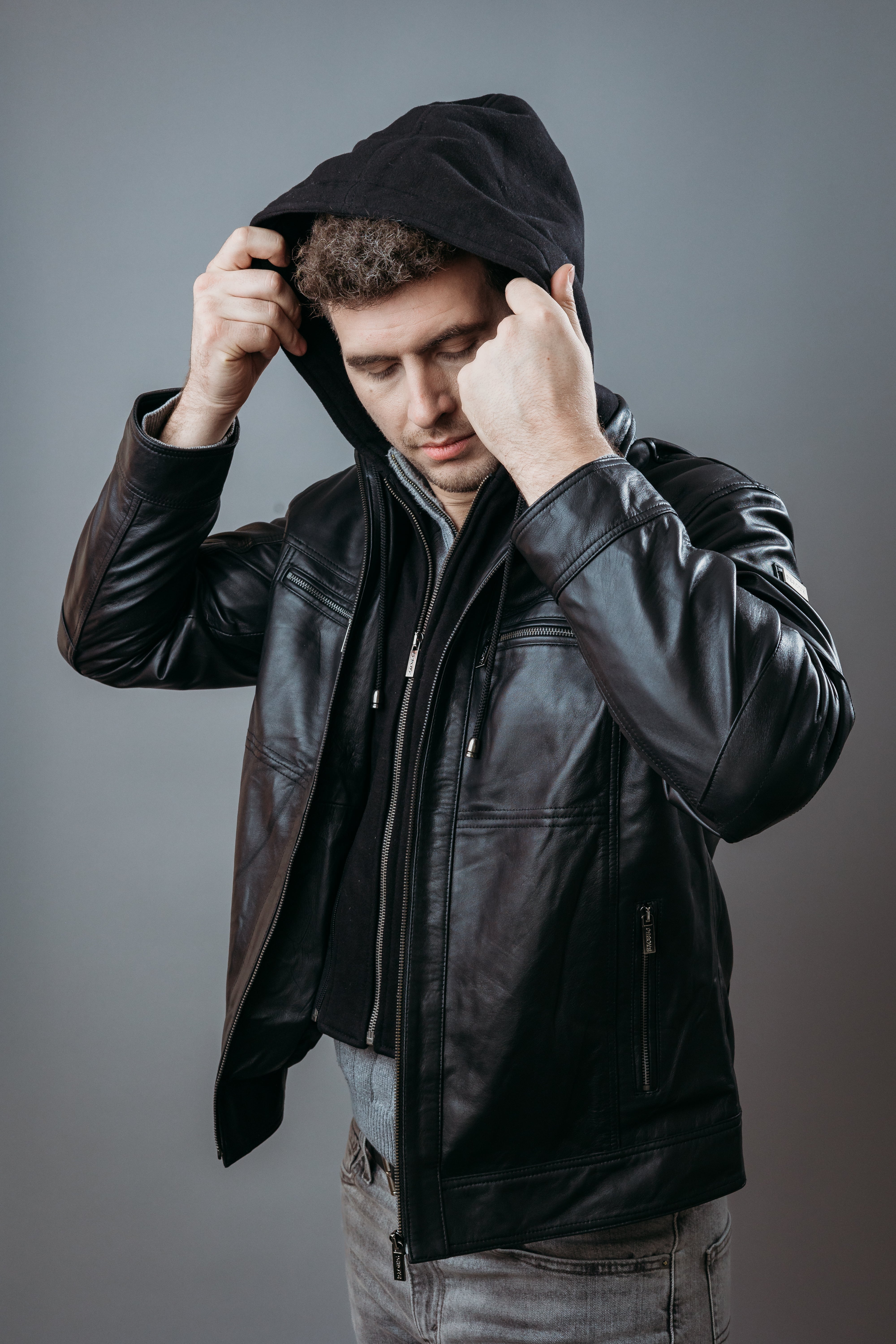 Men's Café Racer Style Hooded Jacket made with Semi Aniline Sheep Leather in Black Colour. Inner Lining is Silk Satin Material in Black Colour. It has Zipper and Gun Metal Trim.