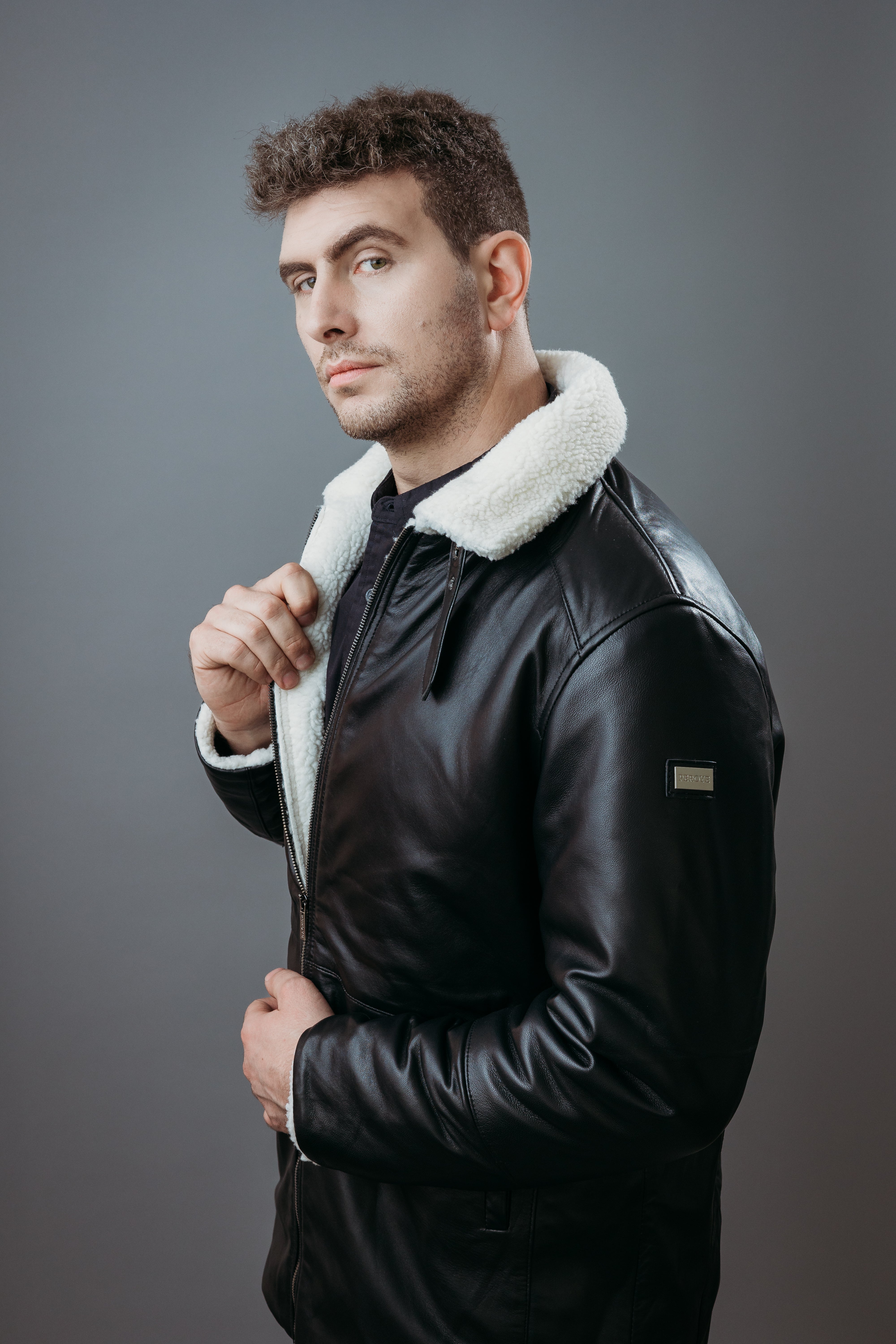 Men's Three Quarter Style Faux Fur Jacket made with Semi Aniline Sheep Leather in Black Colour. Inner Lining is Faux Fur Material in White Colour. It has Zipper and Gun Metal Trim.