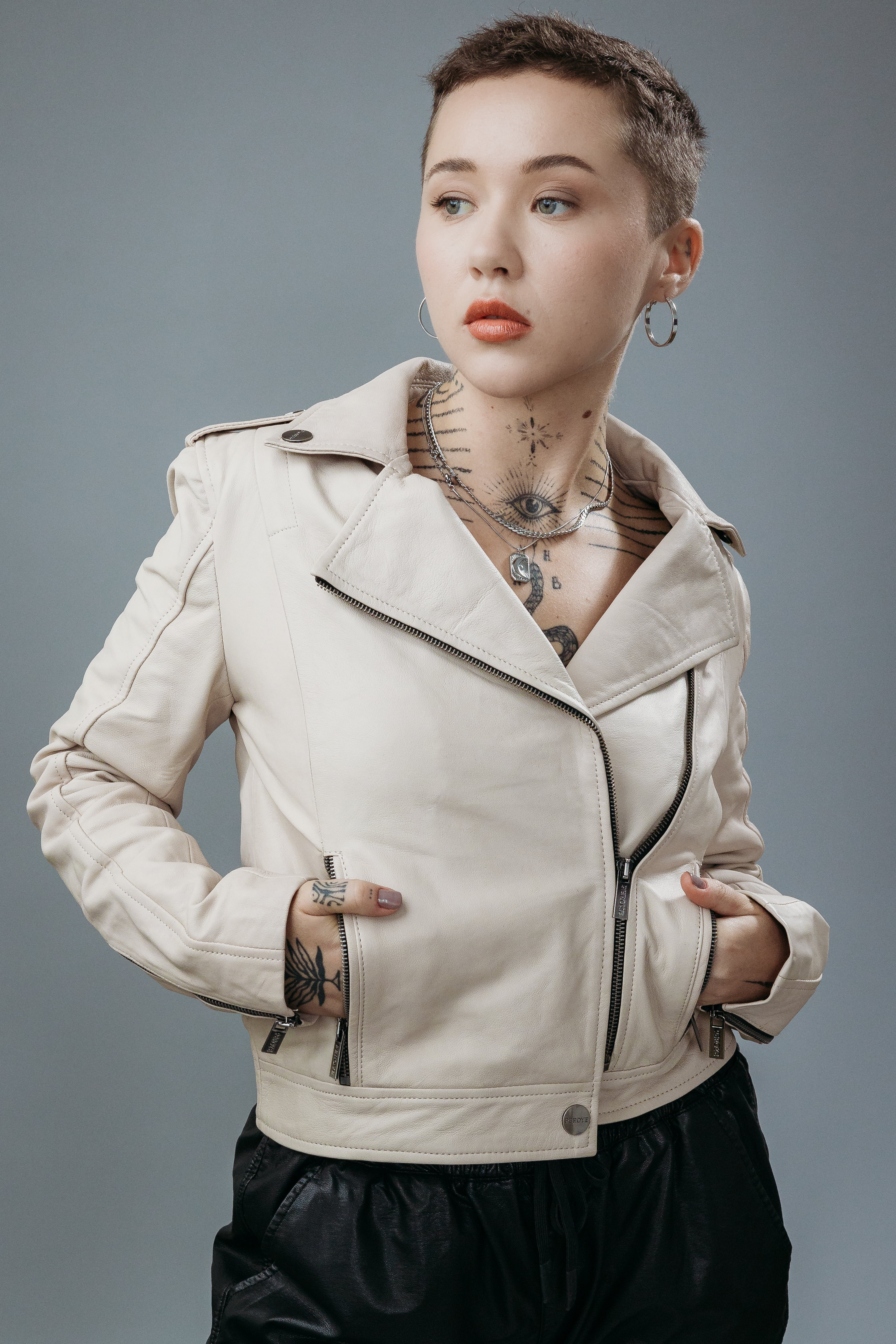 Women's Biker Jacket made with Semi-Aniline Sheep Leather in Off White Colour. Inner Lining is Silk Satin Material in Rust Colour. It has Zipper and Gun Metal Trim.