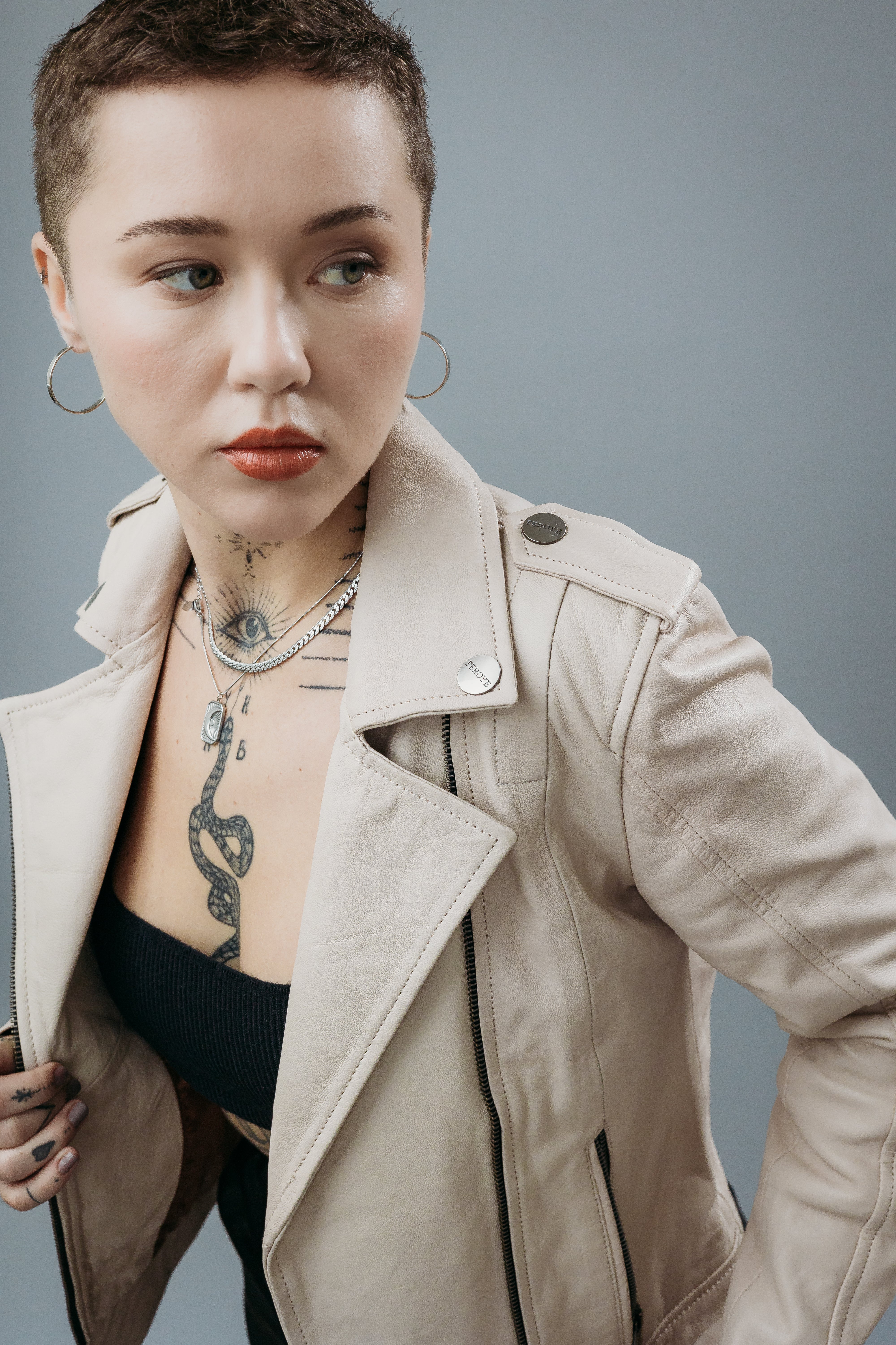 Women's Biker Jacket made with Semi-Aniline Sheep Leather in Off White Colour. Inner Lining is Silk Satin Material in Rust Colour. It has Zipper and Gun Metal Trim.