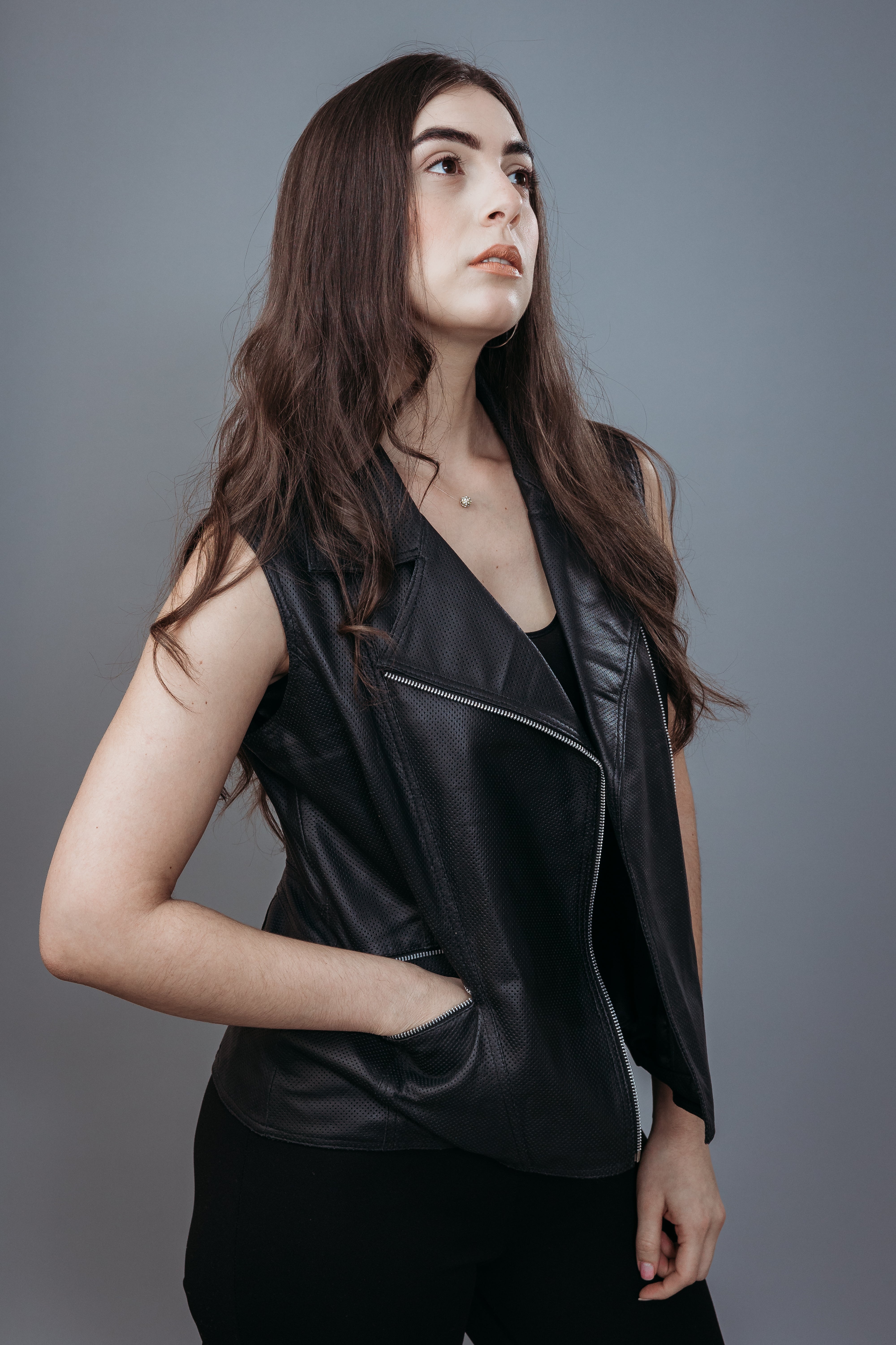 Women's Sleeveless Biker Jacket made with Perforate Semi Aniline Sheep Leather in Black Colour. Inner Lining is Silk Satin Material in Black Colour. It has Zipper and Matte Silver Trim.