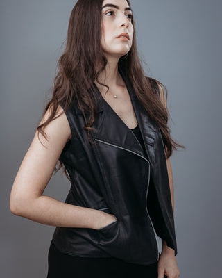 Women's Sleeveless Biker Jacket made with Perforate Semi Aniline Sheep Leather in Black Colour. Inner Lining is Silk Satin Material in Black Colour. It has Zipper and Matte Silver Trim.