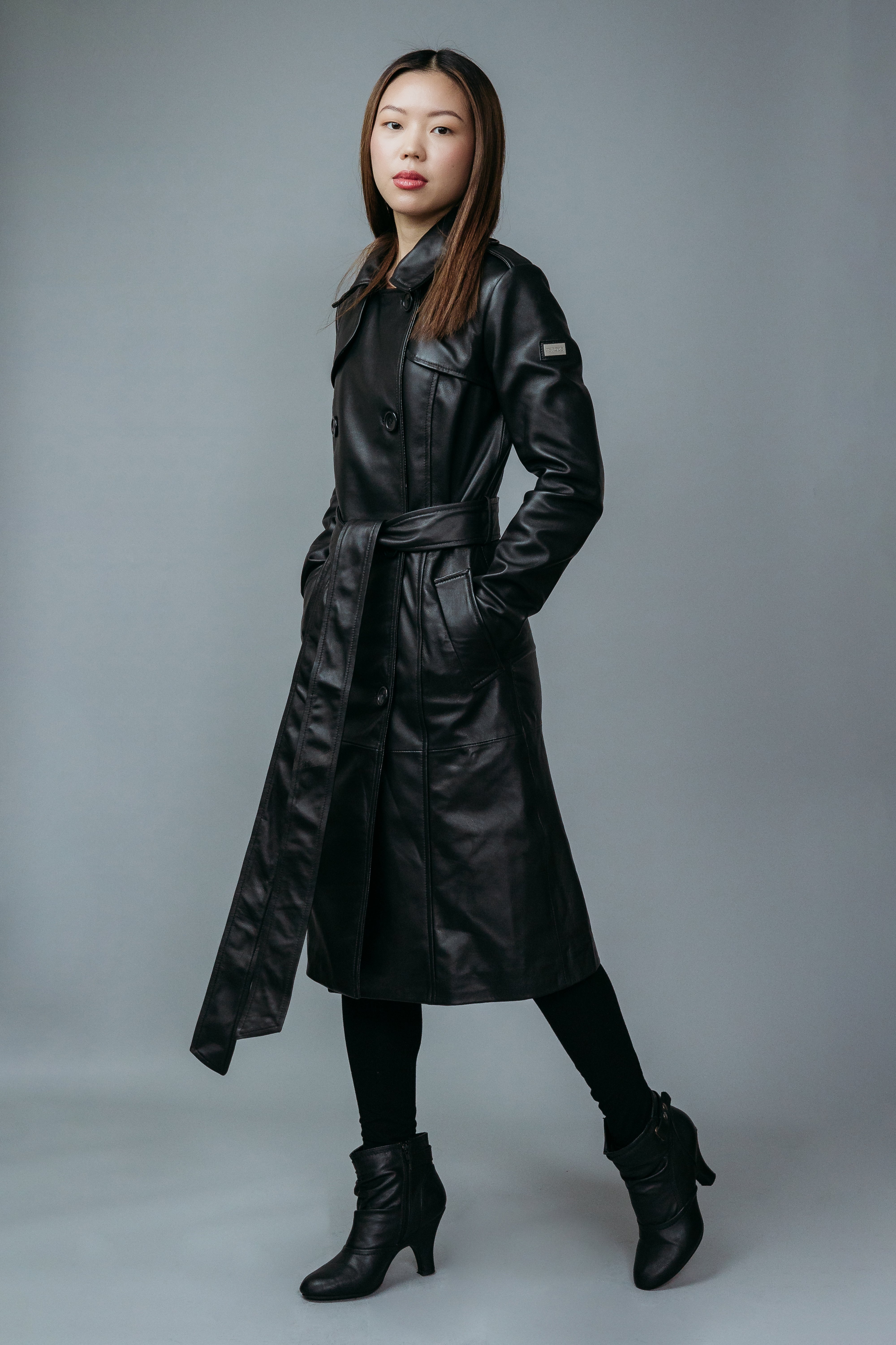 Women's Trench Coat made with Semi-Aniline Sheep Leather in Black Colour. Inner Lining is Silk Satin Material in Black Colour. It has Black Plastic Buttons.