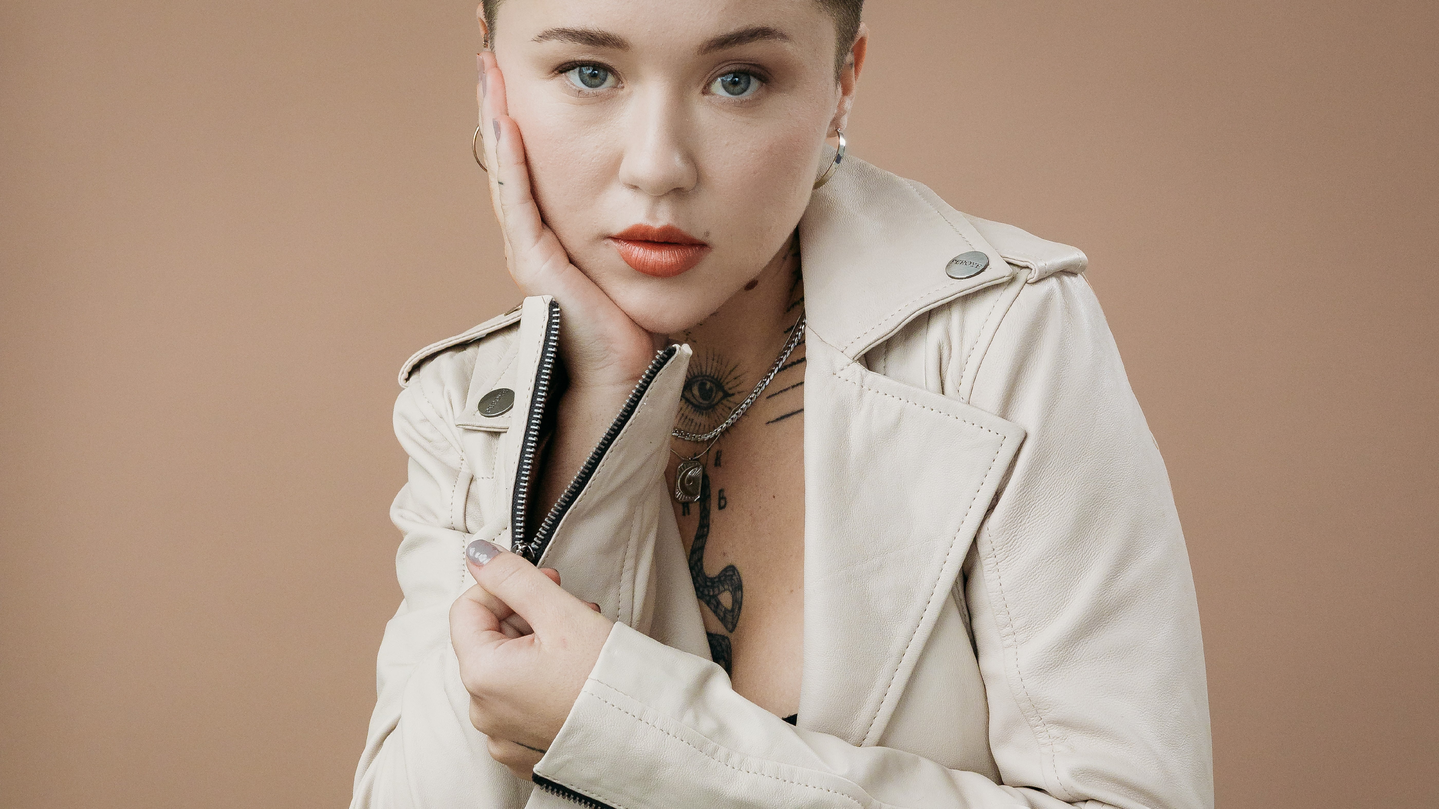 Woman Model Wearing White Peroye Leather Jacket With Rose Gold Background